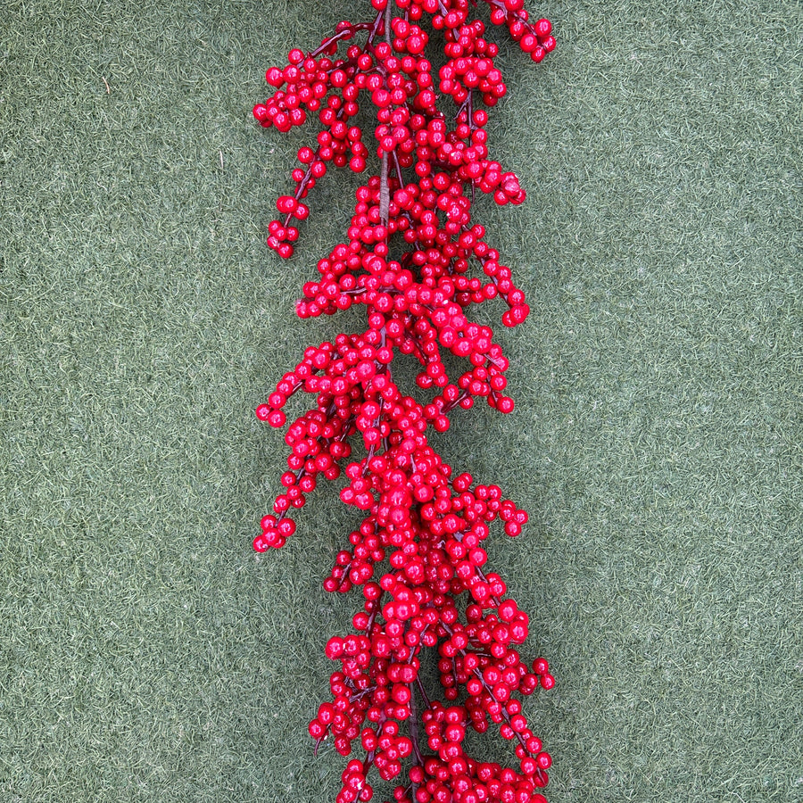 Red berry garland on a green textured background