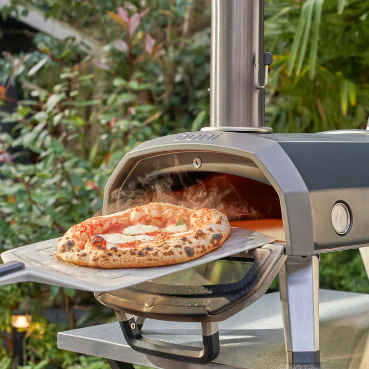 Pizza going into an Ooni Pizza Oven in a garden in Dublin
