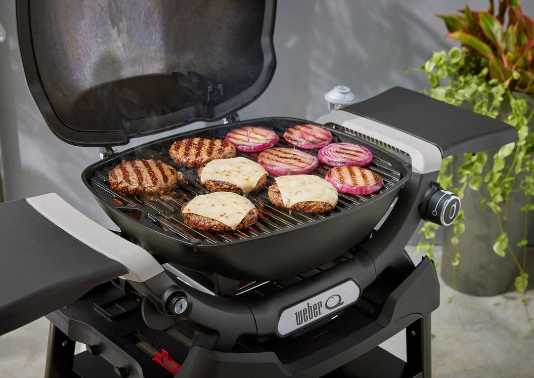 Burgers grilling on  a Weber portable barbecue