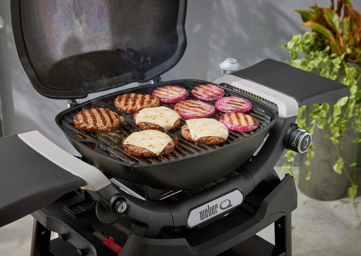 Burgers grilling on  a Weber portable barbecue
