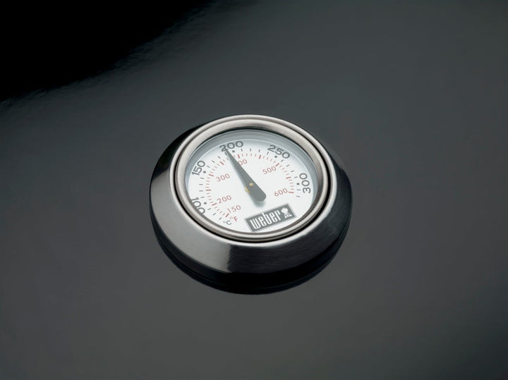 Thermometer on a black Weber barbecue lid