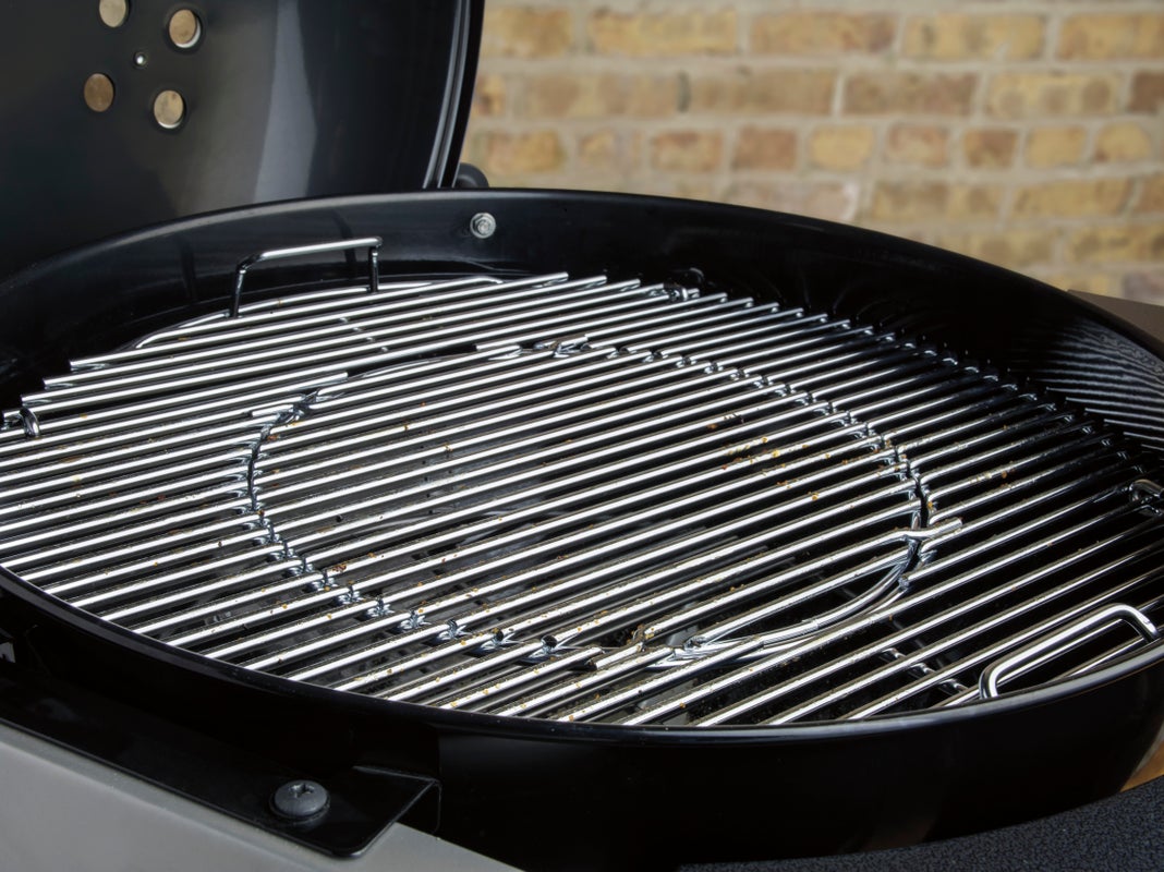 Weber Performer Deluxe grill grates in front of a brick wall
