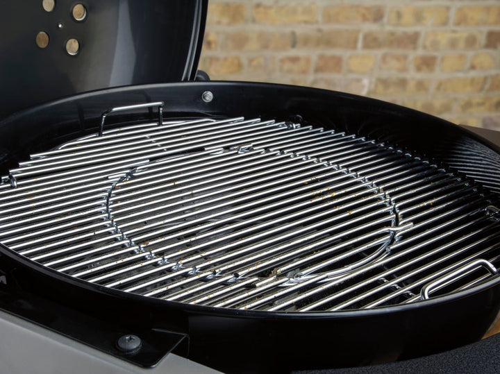 Weber Performer Deluxe grill grates in front of a brick wall
