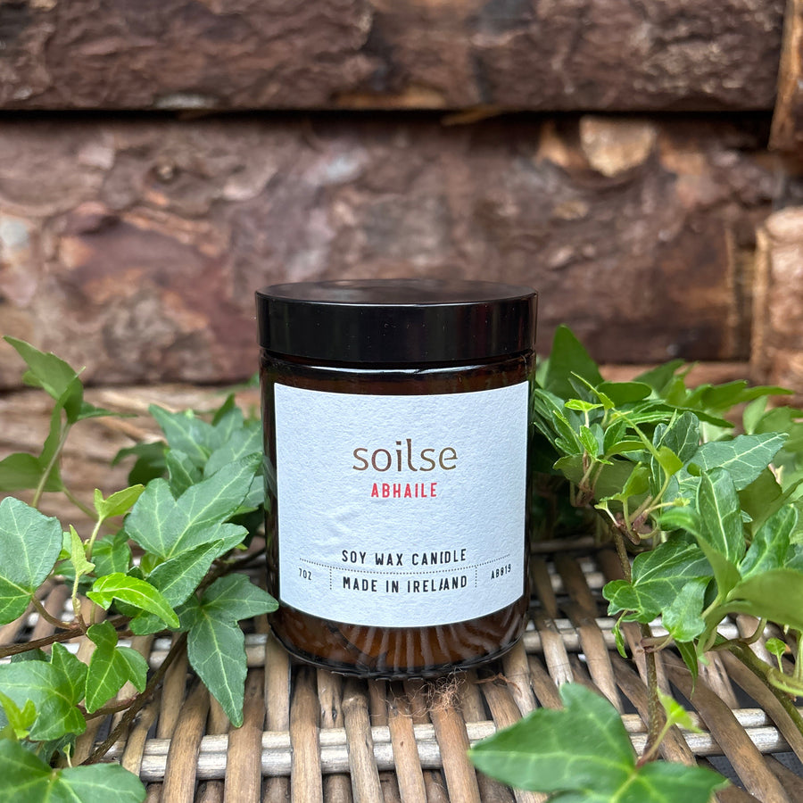 Soilse Homecoming Apothecary Amber Jar Candle with garden floral, honey, and tobacco scent notes