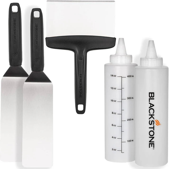 Blackstone griddle tool set with spatulas and measuring bottles on a white background