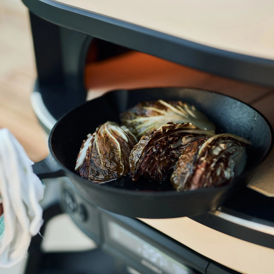 Grilled cabbage in a black skillet on a Gozney pizza oven