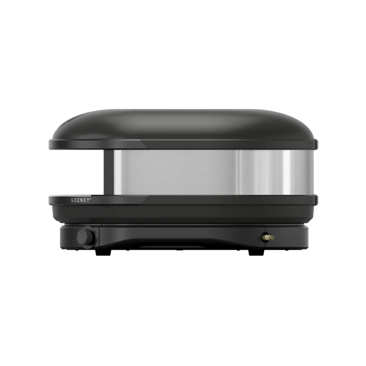 Side view of a black Gozney pizza oven on a white background