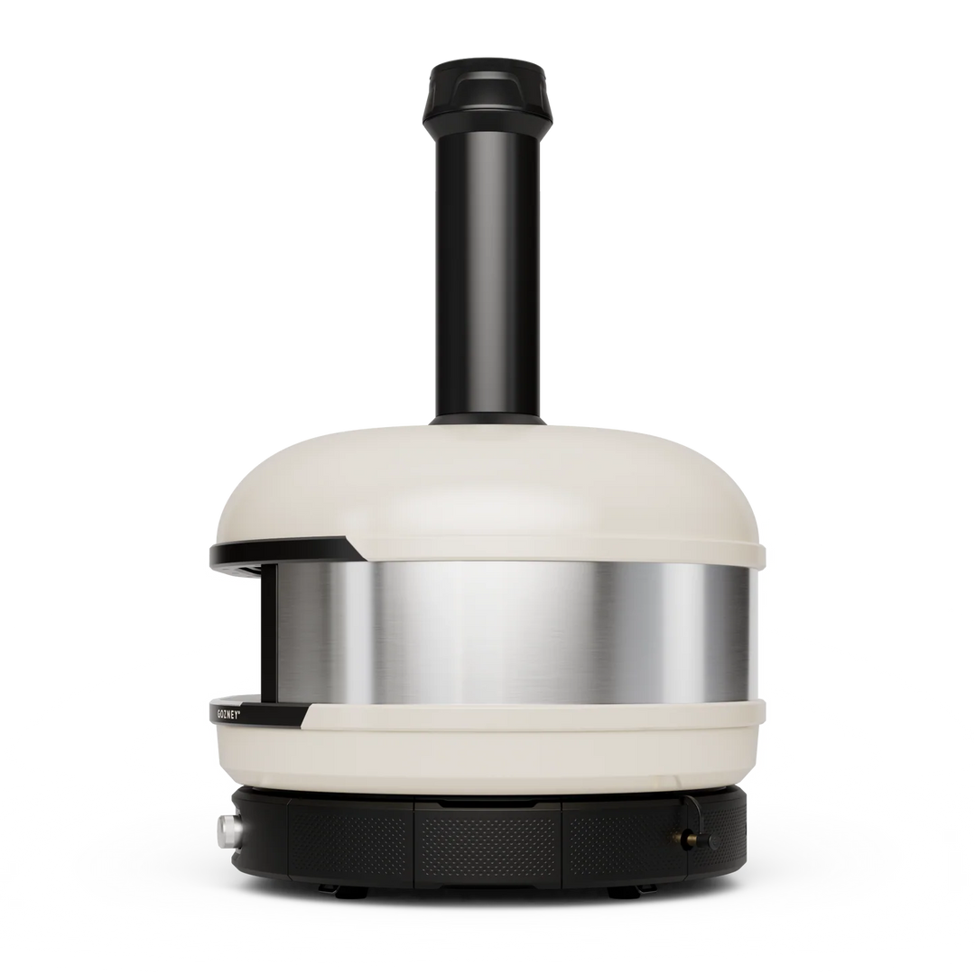 A Gozney Dome pizza oven with a cream-colored ceramic exterior, a brushed stainless steel inner chamber, and a black metal chimney and base, shown against a solid white background.