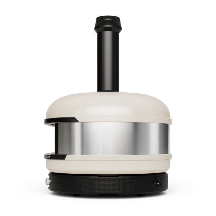 A modern Gozney Dome XL pizza oven with a cream-colored exterior, a brushed stainless steel band around the middle, and a black chimney stack and base, shown on a solid white background.