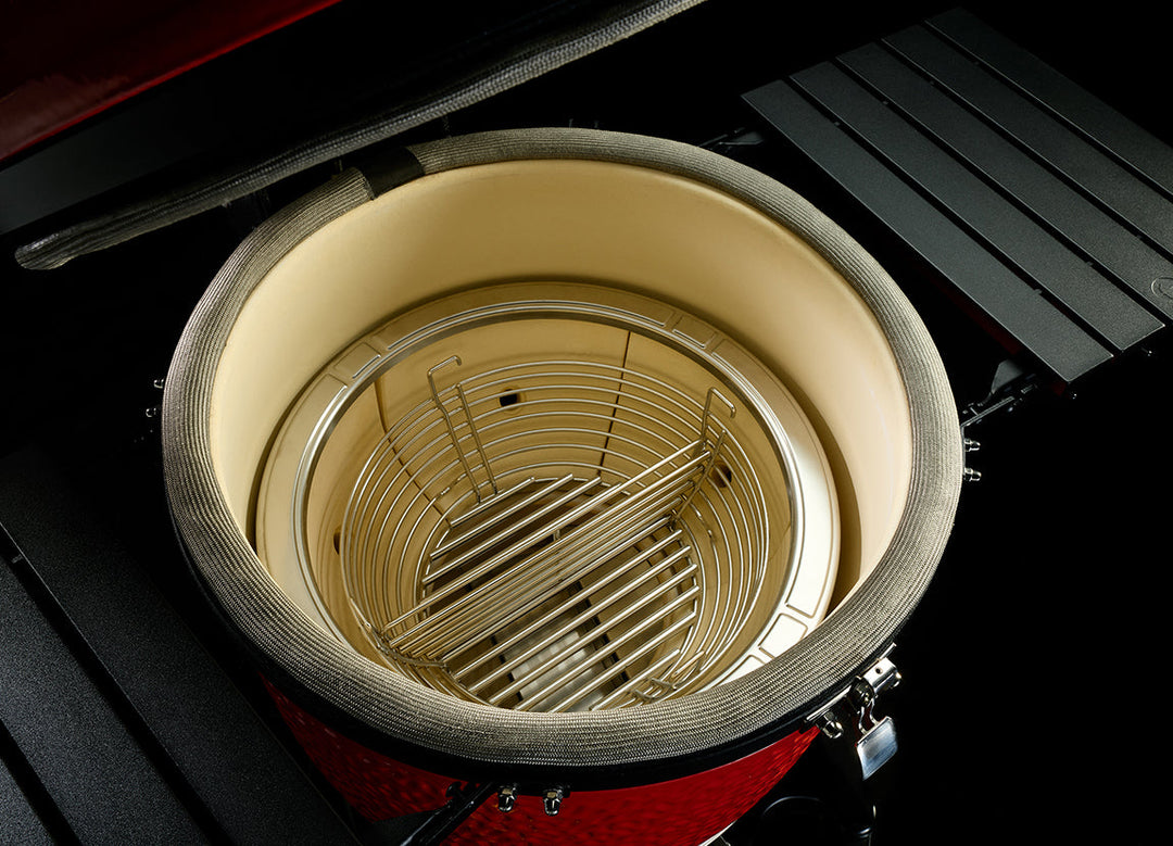 Interior of the Kamado Joe Big Joe III showing the firebox and divided stainless steel charcoal basket