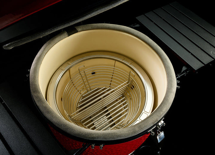 Interior of the Kamado Joe Big Joe III showing the firebox and divided stainless steel charcoal basket