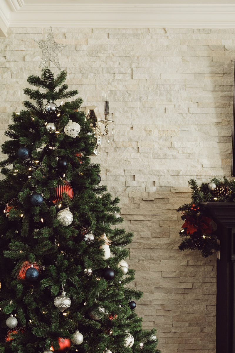 Decorated Christmas tree in front of a brick wall